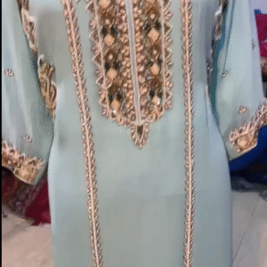 The dress in the image is a traditional-style garment, possibly a kaftan or an embroidered tunic, in a soft pastel blue color.